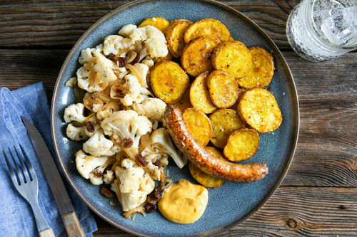 Gebratene Rindswurst und Blumenkohl dazu Röstkartoffeln und Currydip