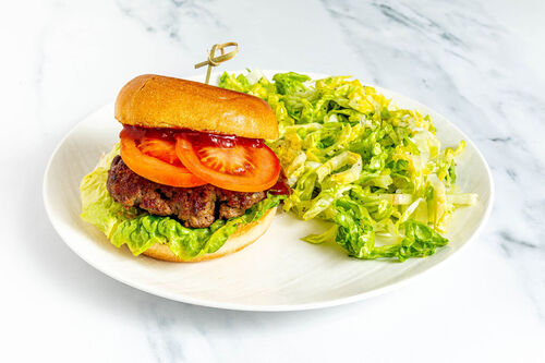 Saftiger Burger mit Rinderhack mit Tomate und Salat