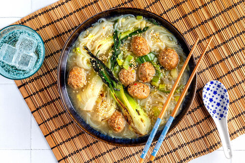 Chinesische Nudelsuppe mit Geflügelbällchen mit Pak Choi und Sesam