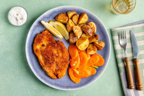 Hähnchenschnitzel mit Röstkartoffeln dazu Karotten, Zitrone und Crème-fraîche-Dip