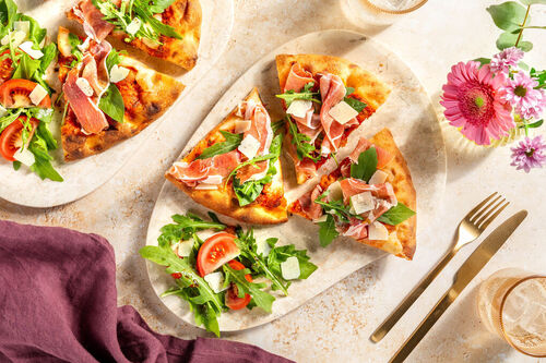 Pizza mit Serranoschinken & zweierlei Käse dazu würziger Rucola-Tomaten-Salat