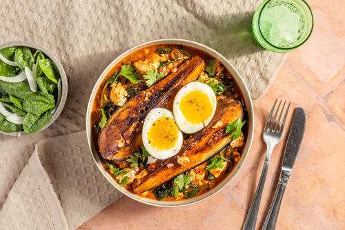 Ei auf Auberginen-Kokos-Curry dazu Spinatsalat