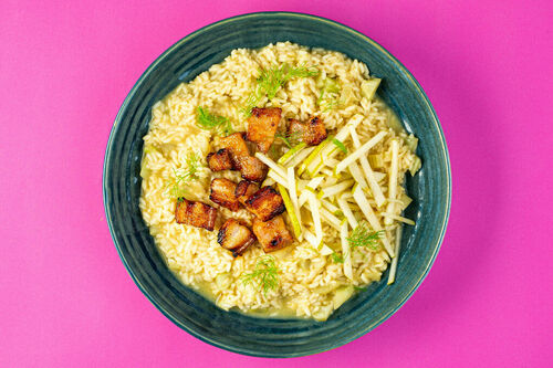 Fenchel-Miso-Risotto mit Knusper-Bacon serviert mit eingelegter Birne