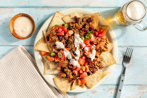 Loaded Nachos mit Chili vom Bio-Rind garniert mit Lauchzwiebeln und Tomaten