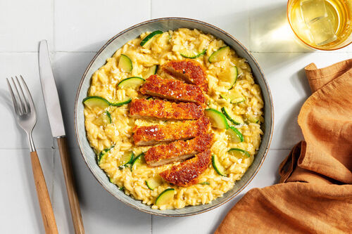Knuspriges Hähnchenschnitzel auf cremigem Mais-Zucchini-Orzotto