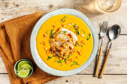 Curry-Kürbis-Suppe mit Hähnchen mit gerösteten Erdnüssen und Lauchzwiebeln