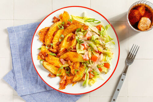 Cheddar-Kartoffelwedges mit Speck serviert mit frischem Salat