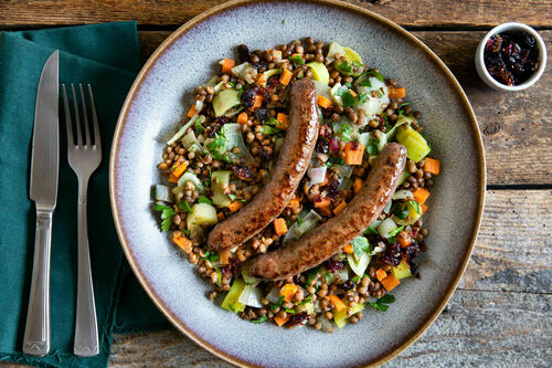 Wildschweinbratwurst auf Linsensalat mit Cranberrys und Zwiebeln