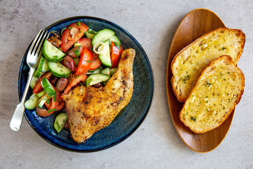 Hähnchenkeule mit Knobibaguette und Tomaten-Gurken-Salat mit Oliven