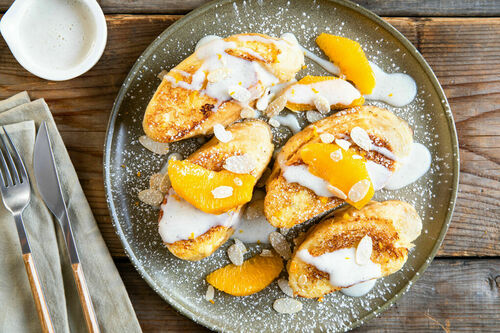 Süße Pofesen mit Aprikosenmarmelade dazu Vanillesauce und Orange