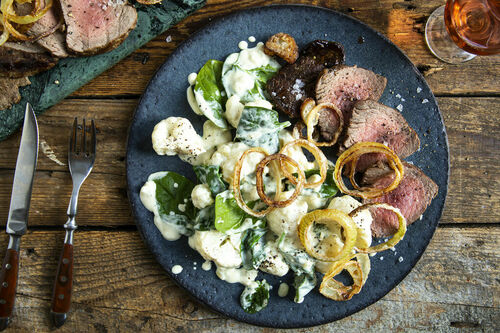 Deftiges Rindersteak mit Röstzwiebeln auf cremigem Blumenkohl mit Spinat