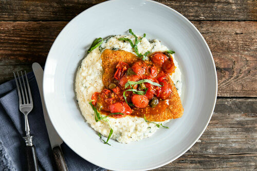Veggie-Schnitzel auf Blumenkohlpüree mit Käse, dazu Kirschtomatensauce