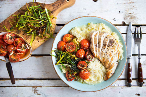 Risotto mit Hähnchen und Knusper-Lauch mit Kirschtomaten und Käse