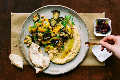 Hummus mit gegrilltem Gemüse dazu Oliven und warmes Pitabrot