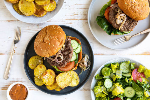 Burger mit BBQ-Sauce dazu knusprige Ofenkartoffeln und Salat