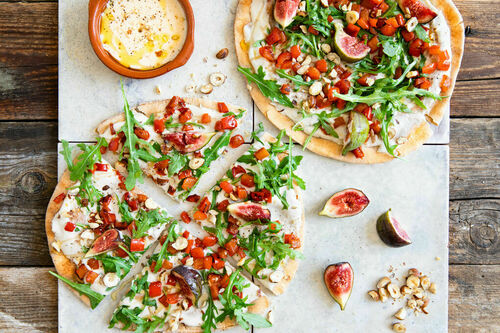 Paprika-Feigen-Pizza mit Bohnencreme auf Vollkorn-Fladenbrot mit Rucola und Nüssen