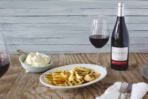 Gegrilltes Obst mit Kokossahne und einer Flasche Côtes du Rhône