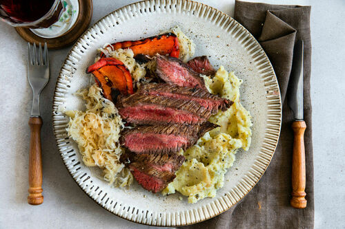 Rindersteak auf buttrigem Kartoffelpüree mit Sauerkraut und gegrillter Paprika