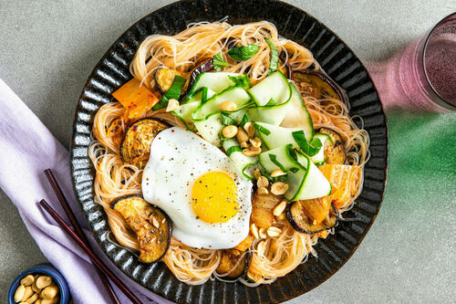 Glasnudeln mit Aubergine und Kimchi serviert mit Spiegelei und eingelegter Gurke