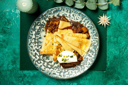 Special: Crêpes mit Birnenkompott serviert mit Schlagsahne und Pistazien